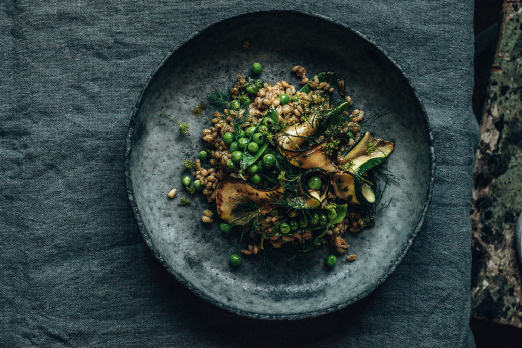 Dark & Moody Foto: Gerste mit Zucchini und Erbsen mit Streiflicht fotografiert