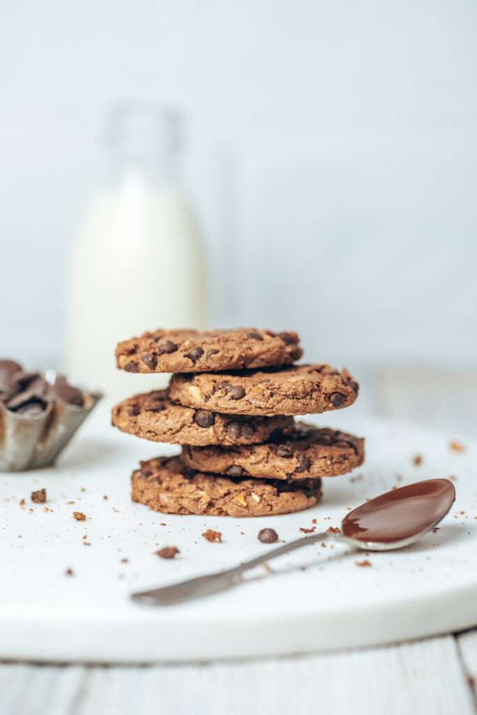 Chocolate Cookies auf einem Marmorbrett mit Milch