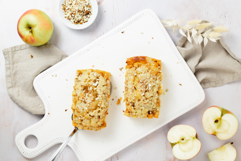 Zwei kleine Apfelkuchen auf eine weißen Brett mit Seitenlicht fotografiert