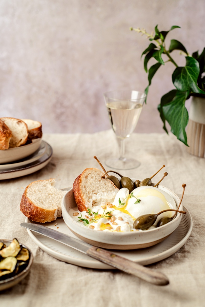 Burrata mit Weißbrot, Kapernbeeren, Zucchini und Weißwein - dolce vita - helle Food Fotografie