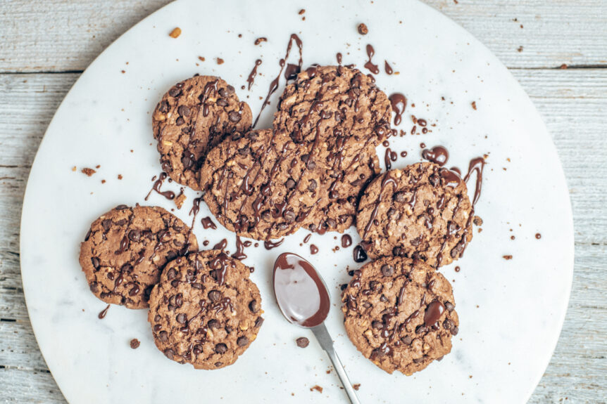 Schokoladen Cookies vor weißem Untergrund mit einer Marmorplatte